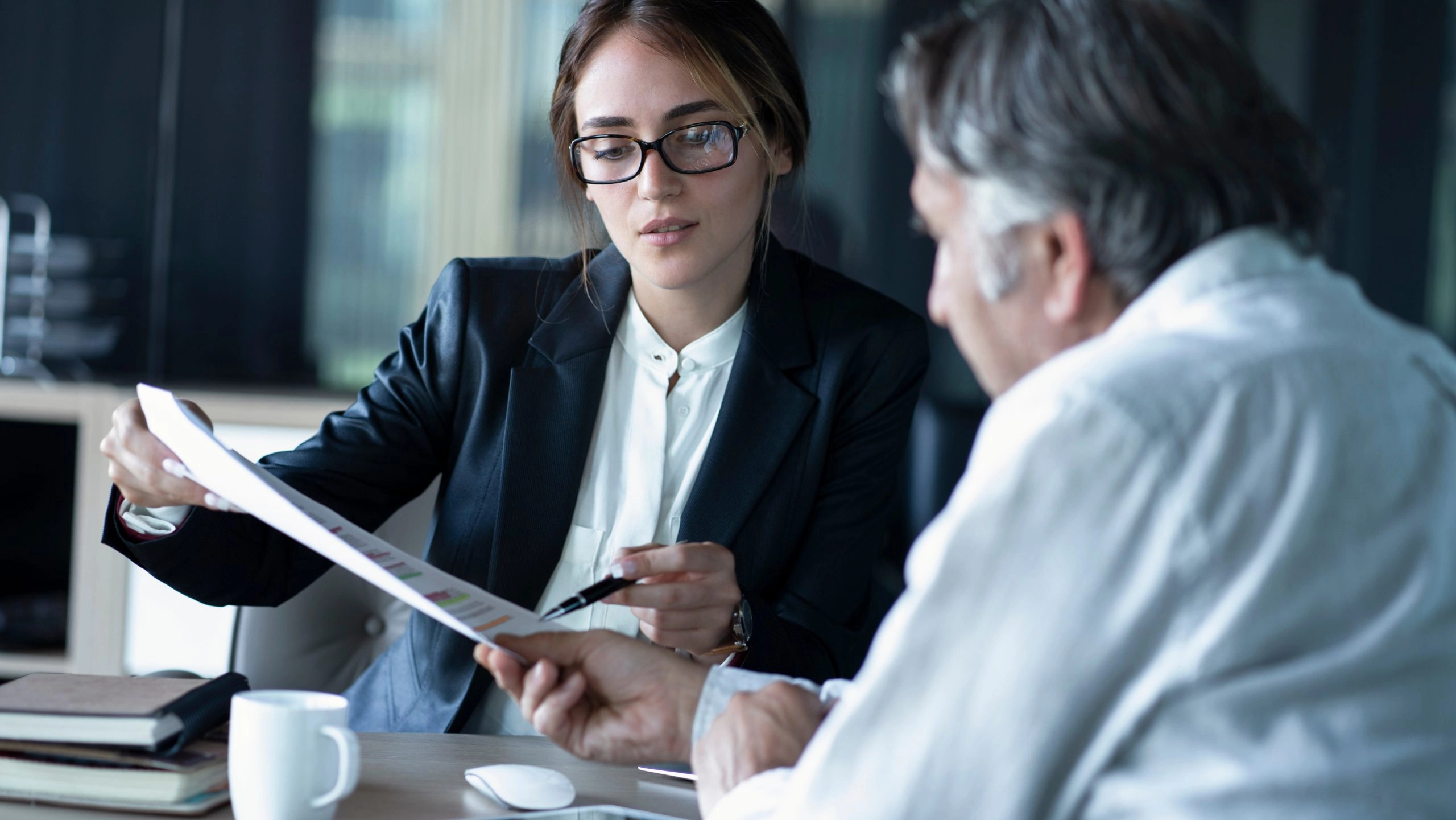Personalberaterin und Unternehmensvertreter besprechen Unterlagen